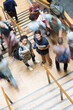 © David Schaffer/KOTO - Elevated view of two smiling students standing on stairs other students going up down