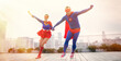 Superheroes holding hands running on city rooftop