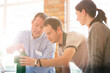 © Martin Barraud/KOTO - Business people stacking green blocks in sunny office