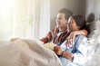 © Tom Merton/KOTO - Teenage couple lying in bed and watching tv