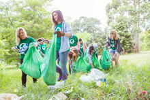 Environmentalist Volunteers Picking Up Trash In Field