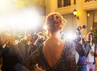 Celebrity being photographed by paparazzi photographers at event