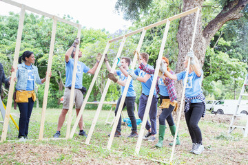 Wall Mural - Volunteers lifting construction frame at construction site