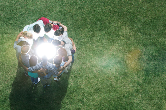 Team huddled in circle around glowing orb in field