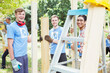 © Robert Daly/KOTO - Portrait of smiling volunteers working at construction site