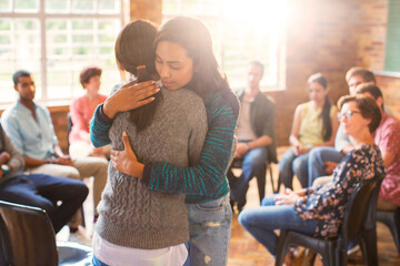 women hugging in group therapy session