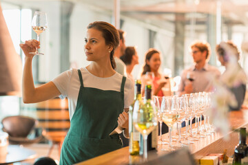 Wine tasting room worker examining white wine