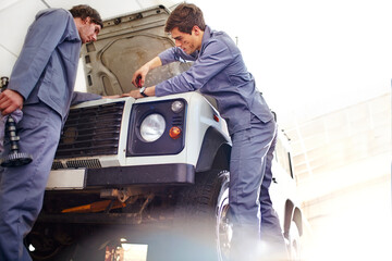 Wall Mural - Mechanics working on engine in auto repair shop