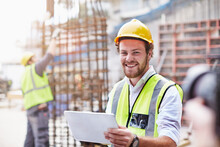 Portrait Confident Construction Worker Digital Tablet At Construction Site