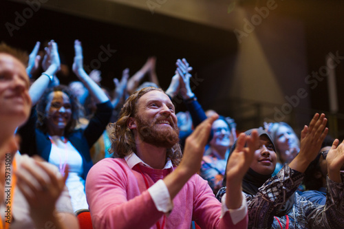 Smiling, enthusiastic man clapping in audience Poster Mural XXL
