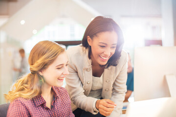 Wall Mural - Smiling businesswoman using computer in sunny office