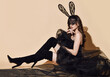 © Dmitry Lobanov - Sensual woman vamp in black lingerie, high boots and lace rabbit mask sits on floor looks at long fata veil
