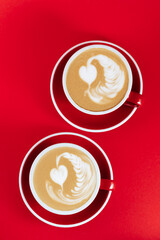 Wall Mural - Hot cappuccino on red table with selective focus on the latte art