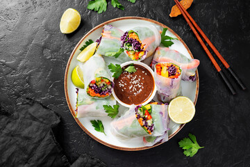 Vegetarian vietnamese spring rolls with peanut butter sauce, carrot, cucumber, red cabbage and rice noodle. Vegan food. 