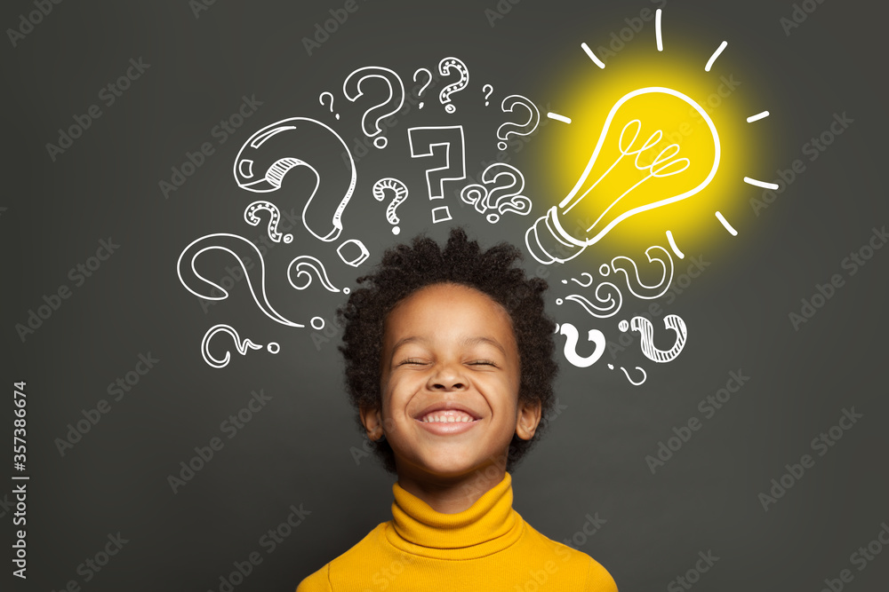 Happy black kid on black background with light bulb and question marks. Brainstorming and idea concept - obrazy, fototapety, plakaty 
