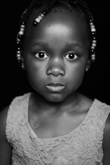 Black and white portrait of little girl with beads in her hair