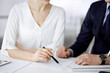 © rogerphoto - Unknown businessman and woman discussing contract in office. closeup.Business people or lawyers working together at meeting. Teamwork and partnership