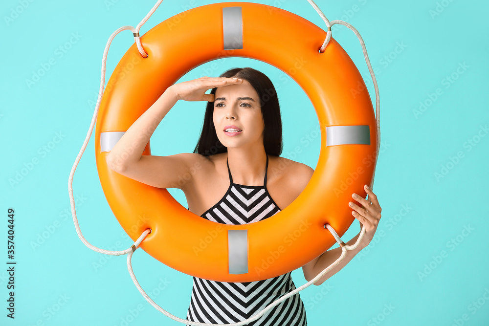 Beach rescuer with lifebuoy on color background