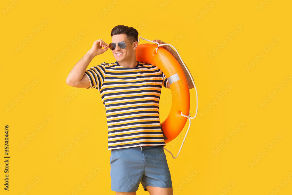 Beach rescuer with lifebuoy on color background