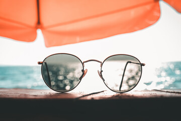 Sunglasses on the table by the sea on a chill vacation. Summer Holiday and Travel Concept