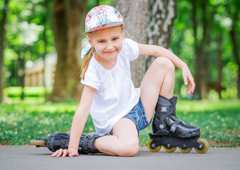 Little smiling girl in roller skates in park