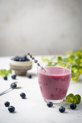 Homemade antioxidant summer blueberry smoothie in a glass on white table