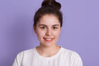 © sementsova321 - Attractive woman with charming smile looking directly at camera, cute lady against lilac background, smiling teenage girl with dark hair and bun, dimpled happy lady.
