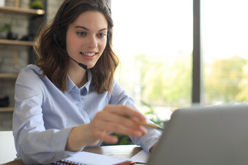 Freelance operator talking with headsets and consulting clients from home office.