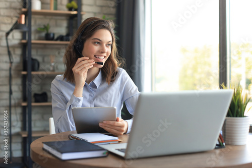 Fotomural Freelance operator talking with headsets and consulting clients from home office