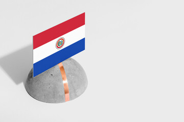 Paraguay flag tagged on rounded stone. White isolated background. Side view minimal national concept.