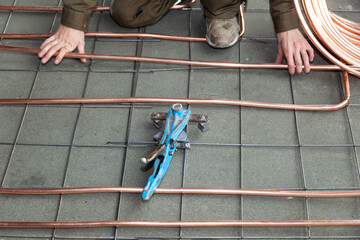 Wall Mural - male hands bends copper pipes by pipe bender