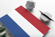Netherlands Flag On Minimalist Paper Background. National Invitation Letter With Stylish Pen On Stone. Communication Concept.