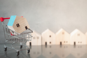 Poster - Wood house in small shopping cart. Concept of shop new house promotion