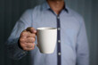 © PisutKP - The man grabs a white cup by right hand