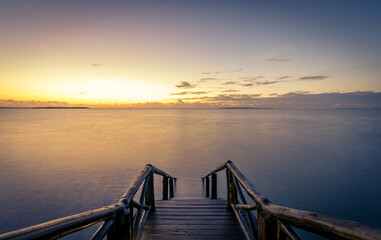  Stairs leading to ocean during sunrise with dreamy water