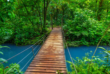 Rio Celeste With Turquoise, Blue Water And Small Wooden Bridge Across The River Tenorio National Park Costa Rica. Central America.