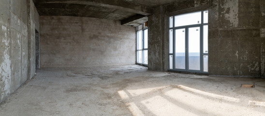 Large spacious room, illuminated by natural light from windows.