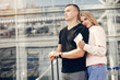 © prostooleh - Couple in a airport. Beautiful blonde in a white jacket. Man in a black t-shirt