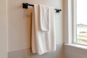 Wall Mural - Black rod with white towel mounted on the bathroom wall with tiles