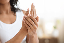 Body Care. Closeup Image Of Black Woman Applying Moisturising Cream On Hands
