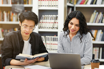 Wall Mural - Two smiling multicultural students learning at public library