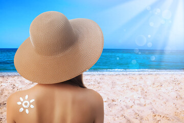 Poster - Woman with sun protection cream on her back at beach, space for text