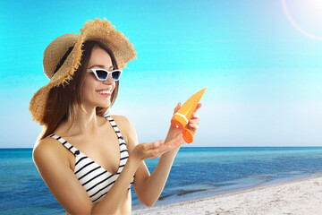 Poster - Young woman applying sun protection cream at beach, space for text