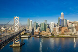 Fototapeta  - Aerial view of the San Francisco, California, skyline at sunrise. Ample copy space in blue sky. Bay bridge in foreground.