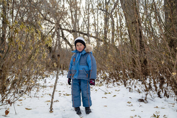 full height portrait of a boy in winter forest