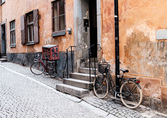 Two bicycles parking in front of a vintage house in a cobblestone street in Stockholm, Sweden