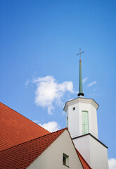 Steeple of a beautiful white Lutheran church in Finland. Bright blue sky and white clouds background with copy space.