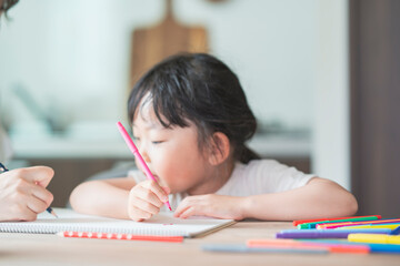 ダイニングテーブルでお絵かきをする子ども