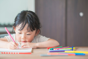 ダイニングテーブルでお絵かきをする子ども