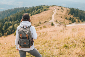 Wall Mural - hiking concept woman with backpack at mountains peak